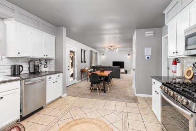 kitchen featuring light tile patterned floors, backsplash, white cabinets, and appliances with stainless steel finishes