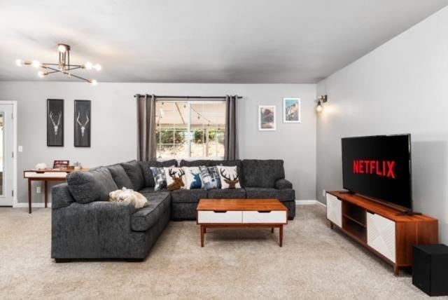 carpeted living room featuring a chandelier