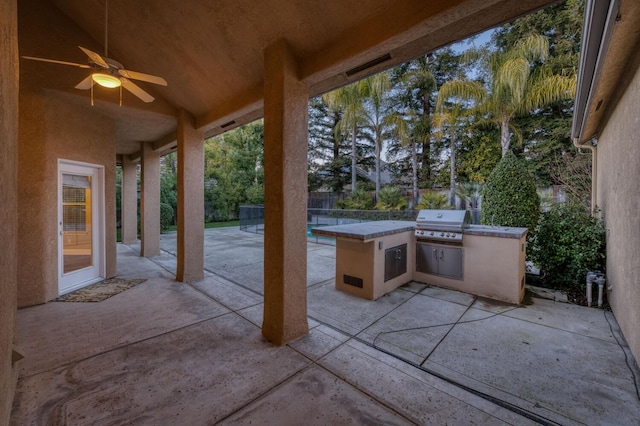 view of patio with ceiling fan, a grill, and exterior kitchen