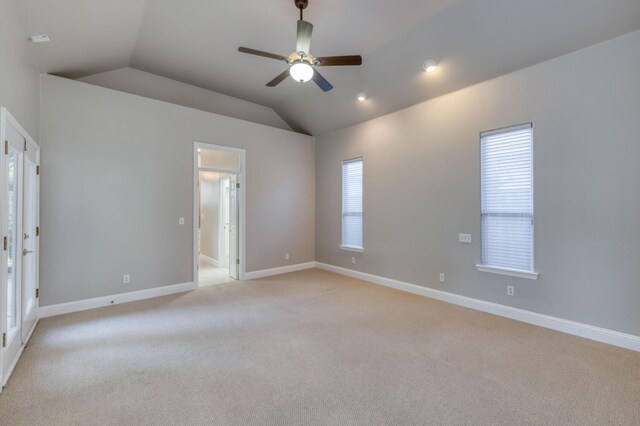 carpeted empty room featuring vaulted ceiling and ceiling fan