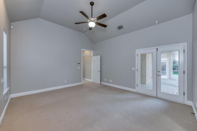 spare room with french doors, vaulted ceiling, and light carpet