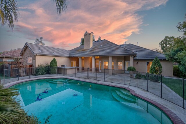 pool at dusk with a patio