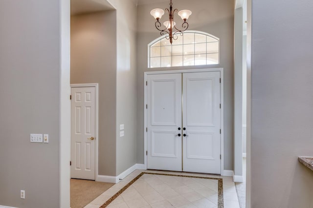 entrance foyer with a notable chandelier, light tile patterned floors, and a high ceiling