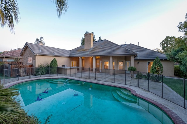 view of swimming pool featuring a patio area and an outdoor kitchen