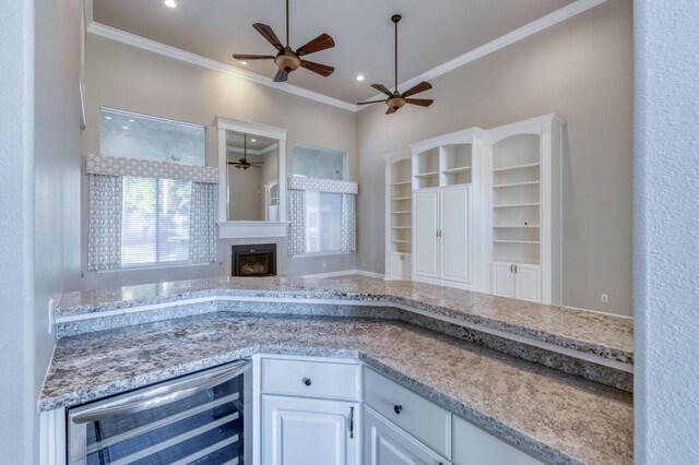 kitchen featuring white cabinetry, wine cooler, and crown molding