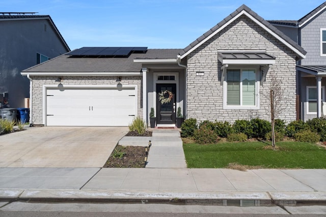 view of front of home featuring a garage, a front yard, and solar panels