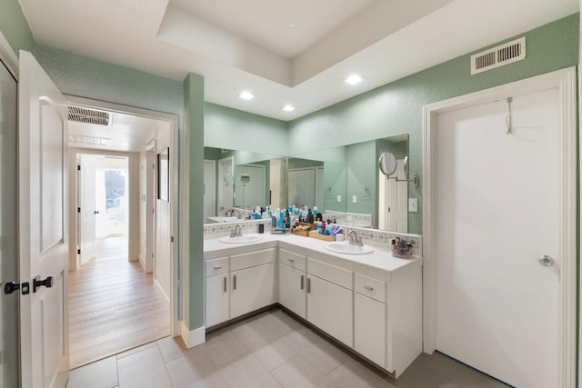 bathroom featuring vanity, tile patterned floors, and a tray ceiling