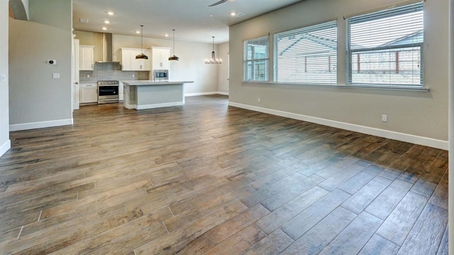 unfurnished living room with dark wood-type flooring and a notable chandelier