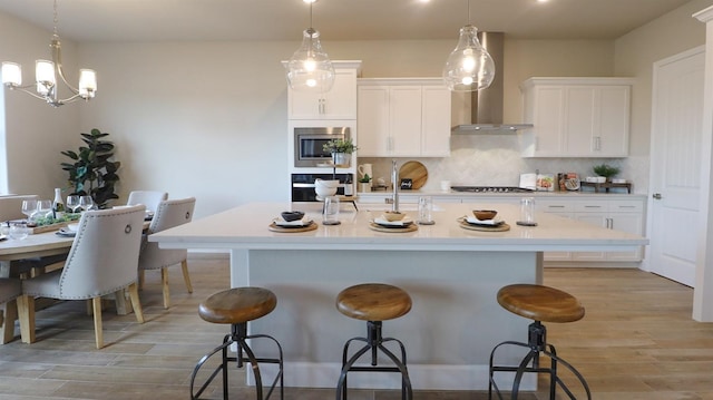 kitchen featuring an island with sink, white cabinets, and a kitchen bar