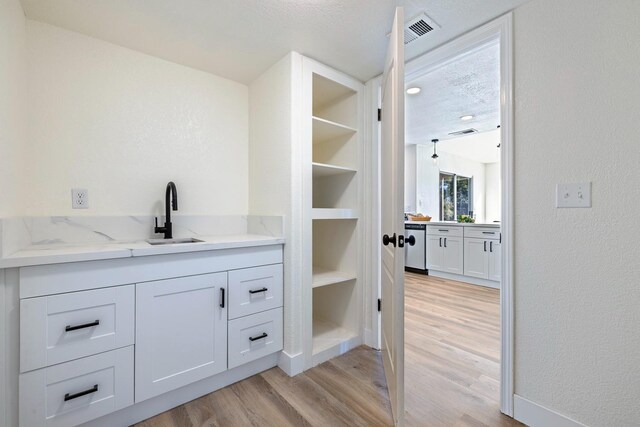 bathroom featuring vanity, wood-type flooring, and a textured ceiling