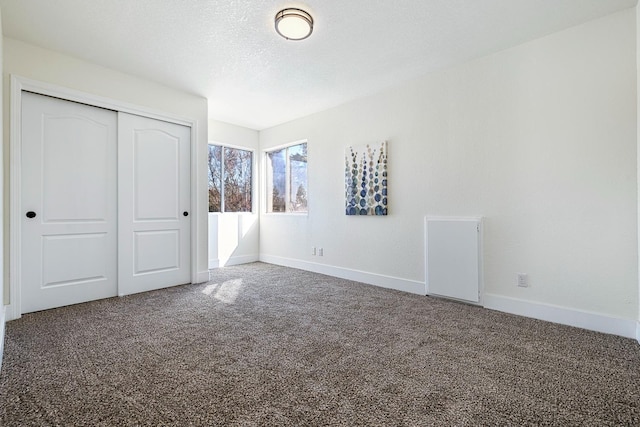 unfurnished bedroom with a closet, carpet floors, and a textured ceiling