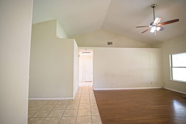 empty room with ceiling fan, lofted ceiling, and light hardwood / wood-style floors