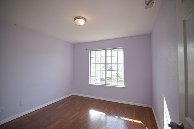 empty room with dark hardwood / wood-style flooring