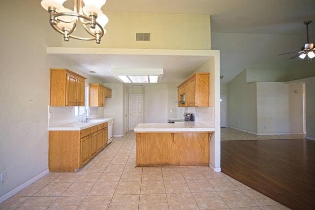 kitchen featuring stainless steel electric range oven, light tile patterned flooring, ceiling fan with notable chandelier, decorative backsplash, and kitchen peninsula