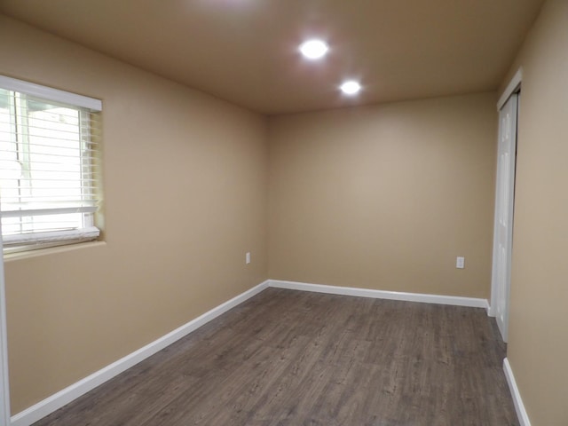 empty room with dark hardwood / wood-style flooring