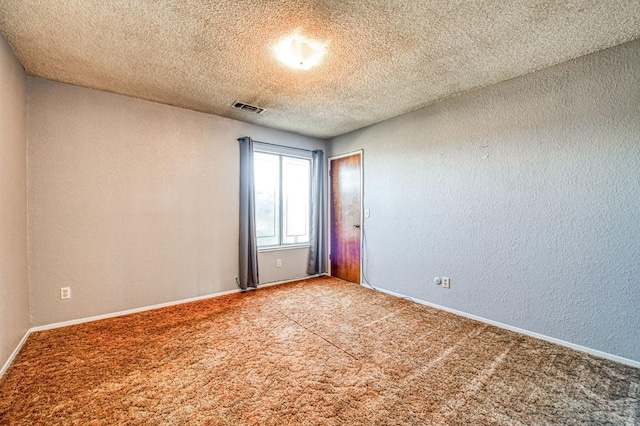 spare room with carpet flooring and a textured ceiling