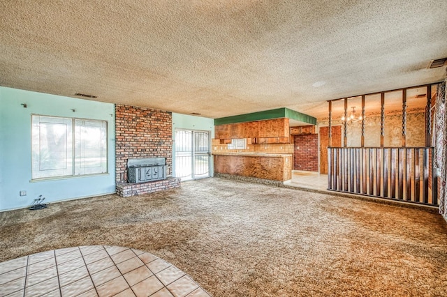 unfurnished living room with light carpet, a textured ceiling, and a fireplace