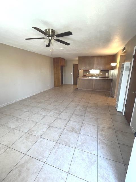 unfurnished living room with ceiling fan and light tile patterned floors