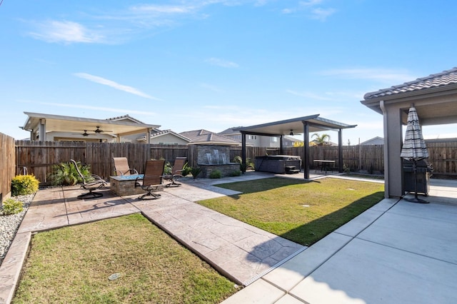 view of yard featuring ceiling fan, a hot tub, and a patio area