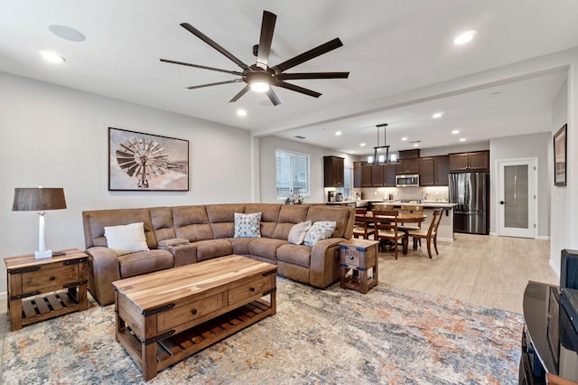 living room featuring ceiling fan and light wood-type flooring