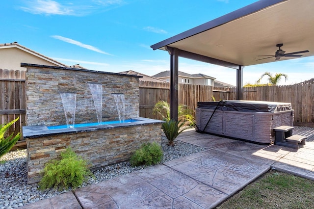 view of patio / terrace with ceiling fan and a hot tub