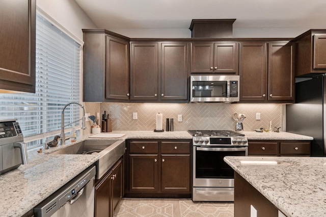 kitchen with sink, backsplash, dark brown cabinets, and stainless steel appliances