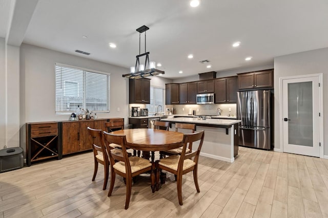 dining room with sink and light wood-type flooring