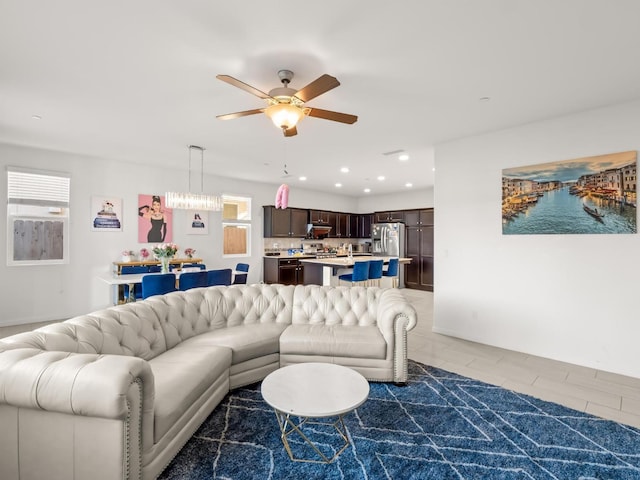 living room featuring ceiling fan, a healthy amount of sunlight, and dark tile patterned flooring