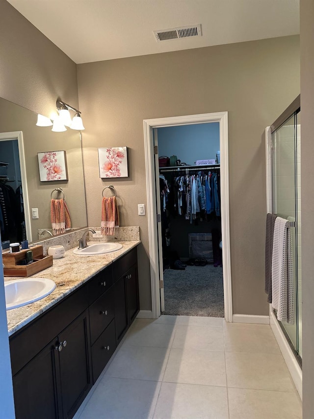 bathroom featuring vanity, tile patterned floors, and a shower with shower door