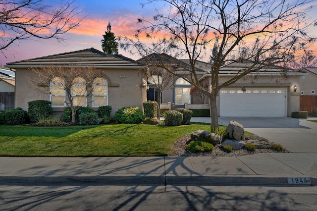 view of front facade with a garage and a yard