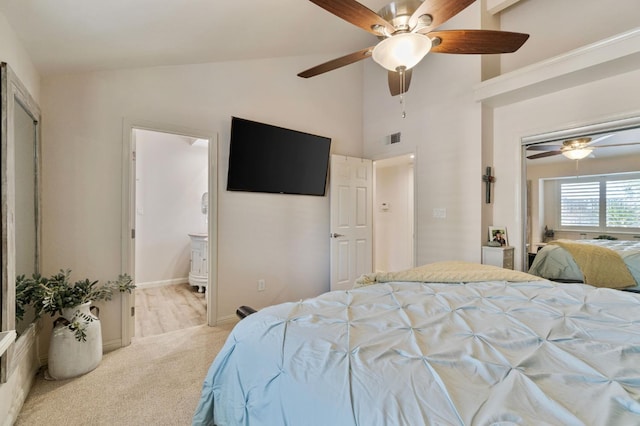 bedroom featuring high vaulted ceiling, light colored carpet, ceiling fan, and ensuite bath