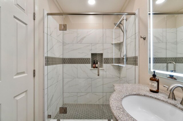 bathroom with vanity, ornamental molding, and walk in shower