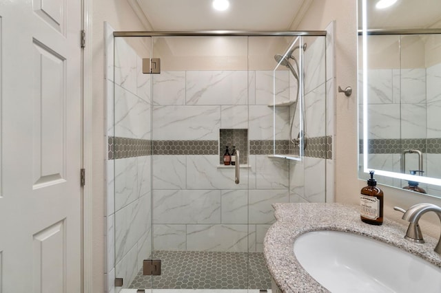 full bathroom featuring ornamental molding, a sink, and a marble finish shower