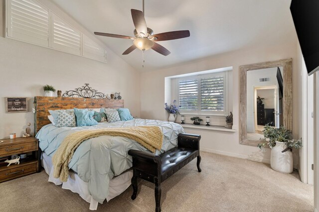 bedroom with ceiling fan, vaulted ceiling, and light carpet