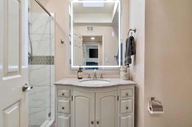 bathroom with vanity and a shower