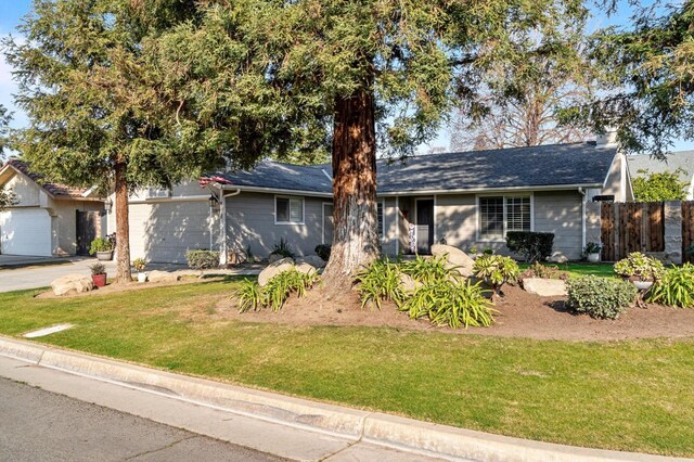 ranch-style home with a garage and a front yard