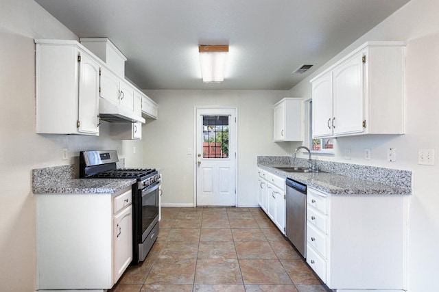 kitchen featuring white cabinetry, sink, light stone counters, and appliances with stainless steel finishes