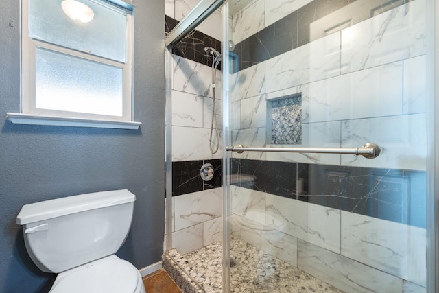 bathroom with an enclosed shower and toilet