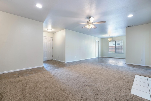 carpeted spare room with ceiling fan with notable chandelier