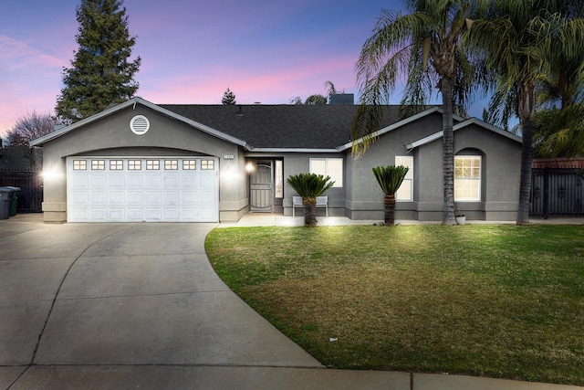 single story home featuring a garage and a lawn