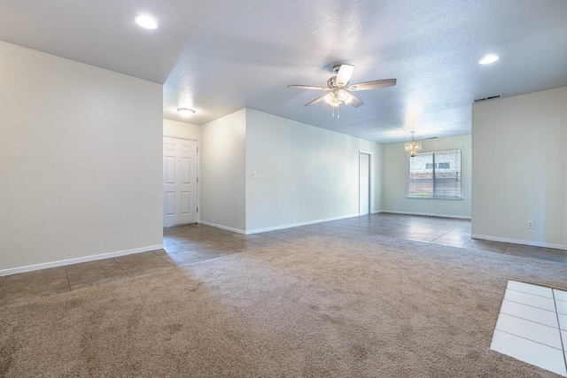 empty room with ceiling fan with notable chandelier, carpet, and a textured ceiling