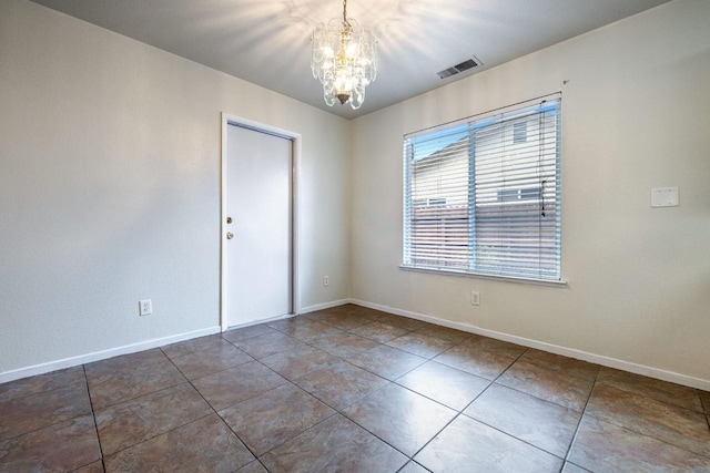 tiled empty room with a notable chandelier