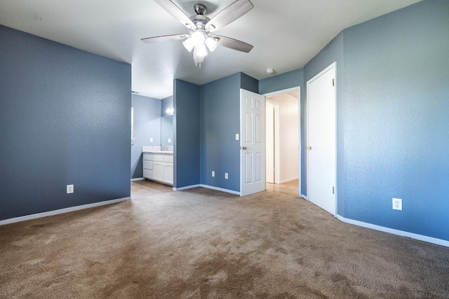 unfurnished bedroom with ensuite bath, light colored carpet, and ceiling fan