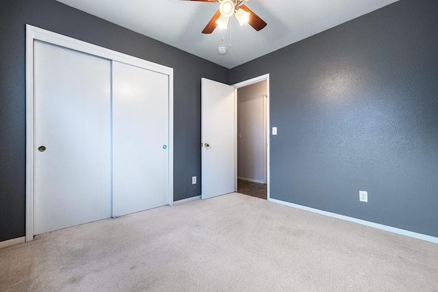 unfurnished bedroom featuring light carpet, a closet, and ceiling fan