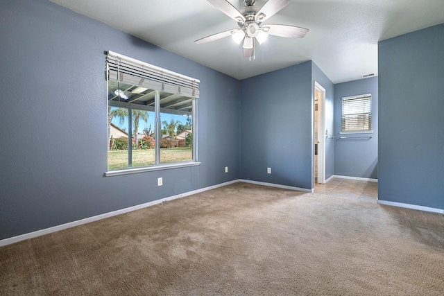 empty room featuring light colored carpet and ceiling fan