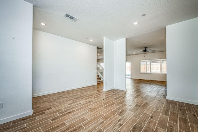 unfurnished room with ceiling fan and a textured ceiling