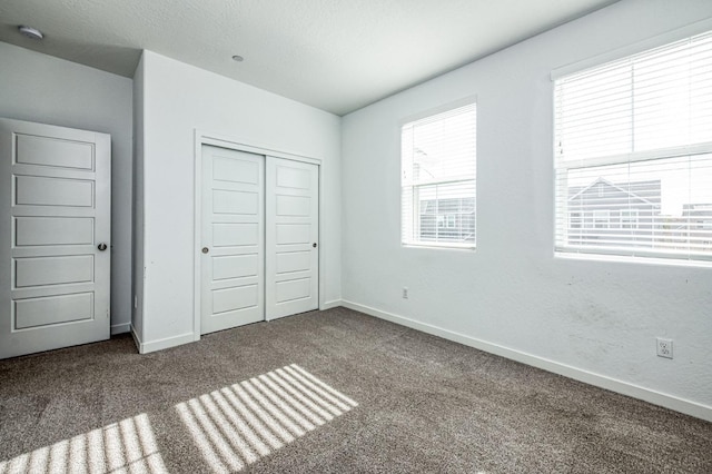 unfurnished bedroom with a closet, a textured ceiling, and carpet