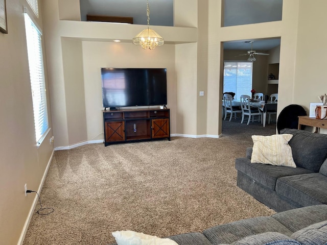 living room with carpet flooring, a wealth of natural light, and a notable chandelier