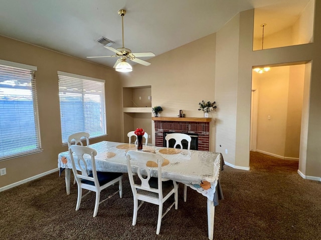 carpeted dining area with a brick fireplace, built in shelves, vaulted ceiling, and ceiling fan