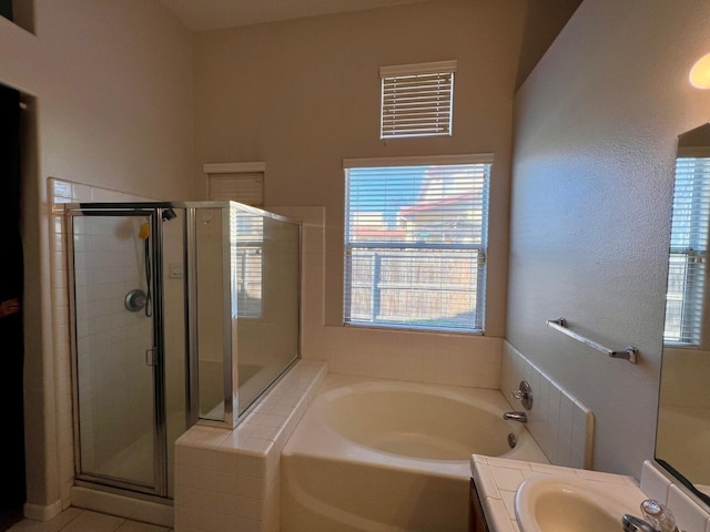 bathroom with vanity, tile patterned flooring, and plus walk in shower